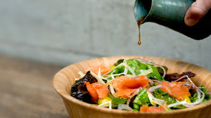 Ensalada de hojas frescas, salmón en slice ahumado en frío, queso parmesano en vinagreta de ajo negro al merquén ahumado